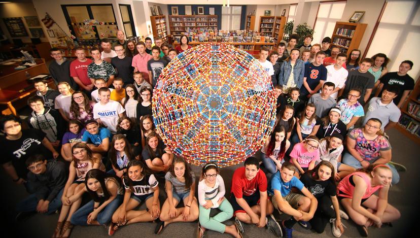 Linda Dodd-Nagel, her 8th-grade math students, Tae Cooke, 和克里斯·希尔围绕着顺柑橘状的多二十面体