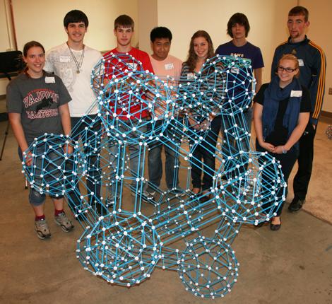学生们在他们完成的项目后面摆姿势:一个元二十面体.